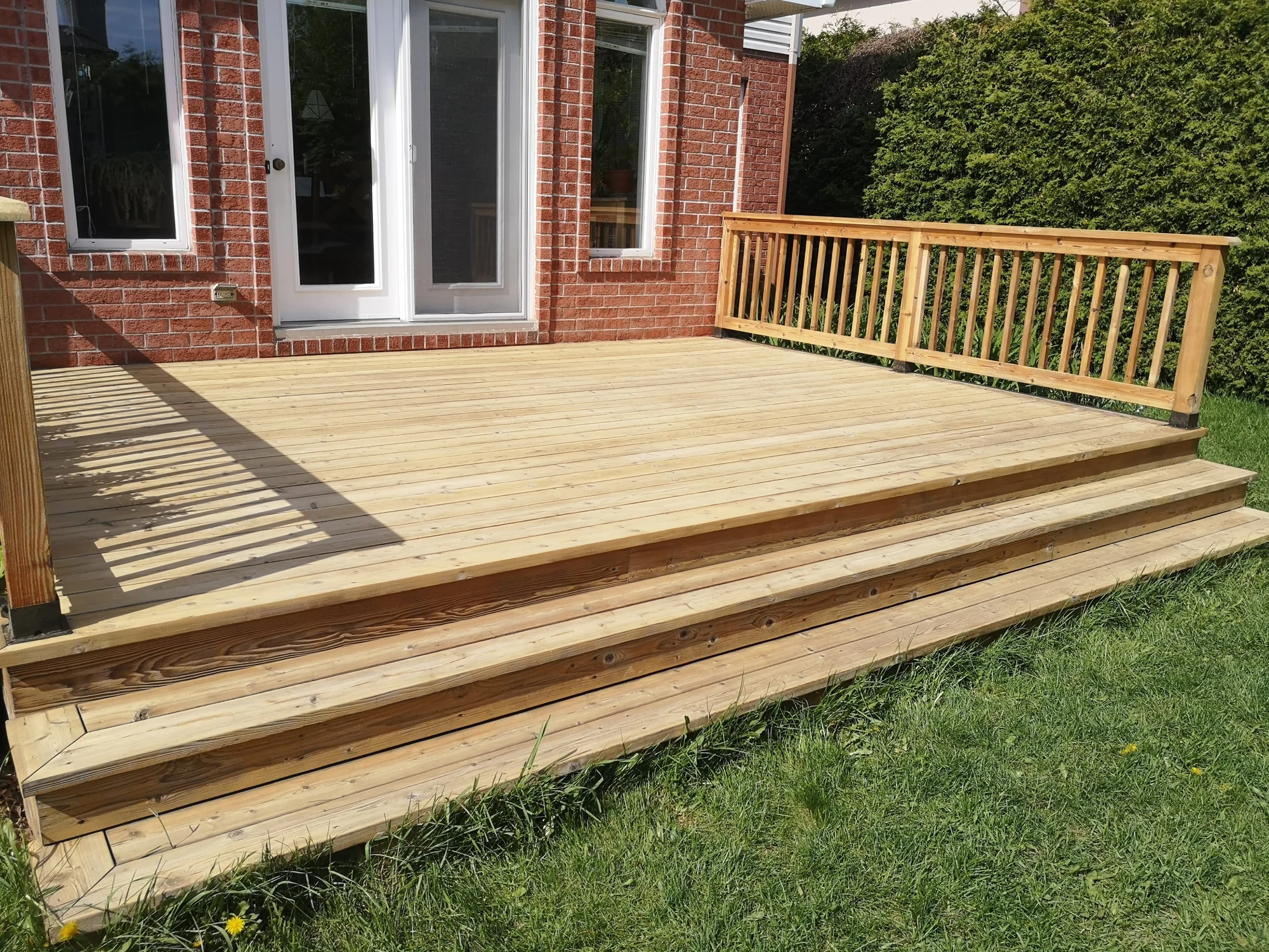 La terrasse avant les travaux, avec son bois clair et sa finition usée.